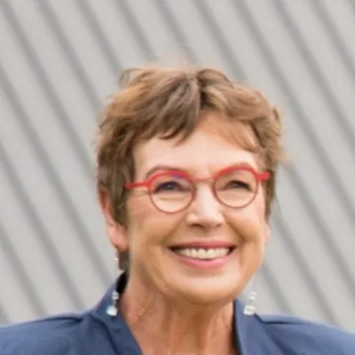 Smiling woman with short hair and red glasses